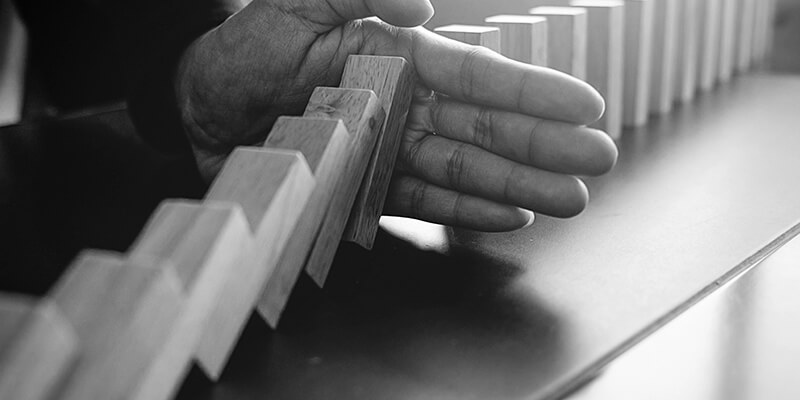 Hand stopping Dominoes from falling