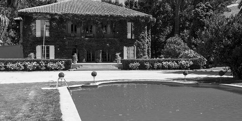 Ivy covered period property surrounded by greenery with swimming pool