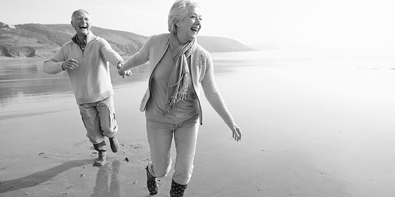 Happy retired couple frolicking on a beach