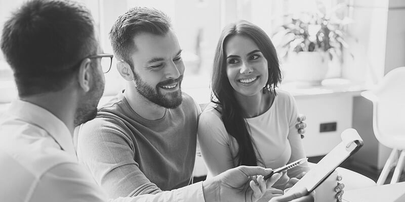 Happy couple planning their savings with a financial expert