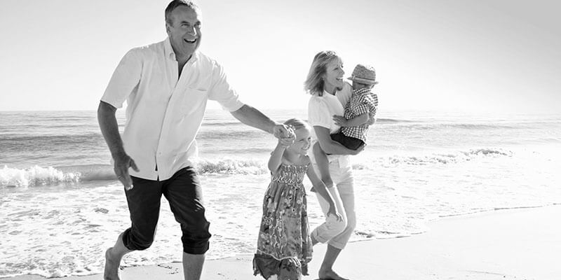 Happy family on a beach running from the sea