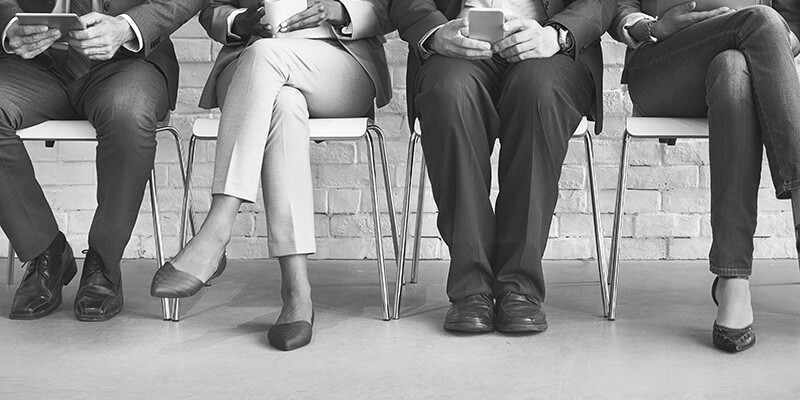 Legs of business people in waiting room