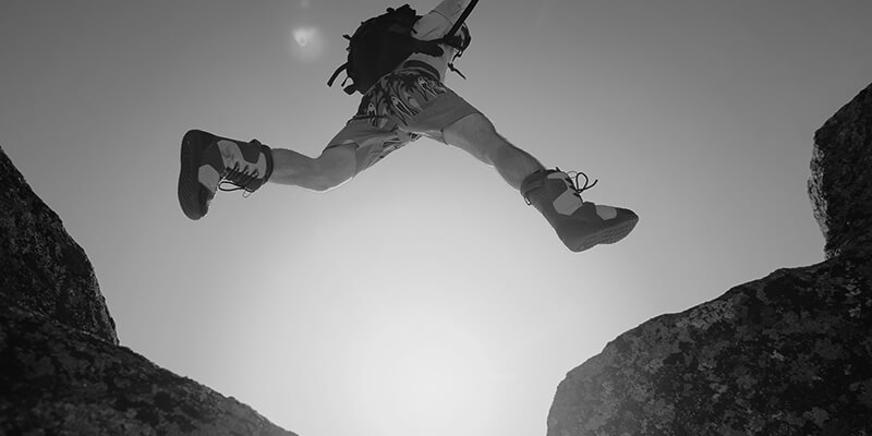 Hiker leaping between rocks