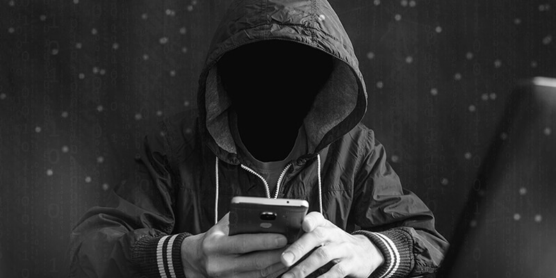 Faceless figure in tracksuit looking at mobile phone