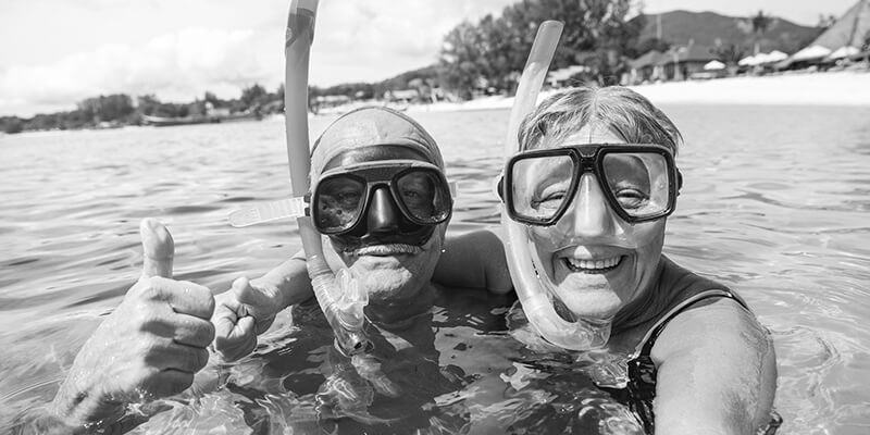 Happy retired couple enjoying snorkelling